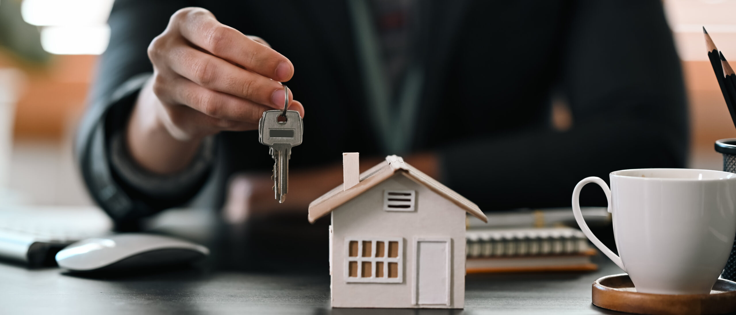 Cropped shot real estate agent  holding house key. Insurance or